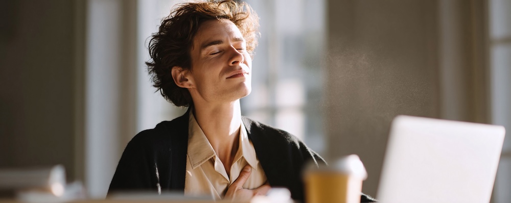 Man basks in sunlight, eyes closed in serene bliss. Captures relaxation, mindfulness, and a moment of peace, ideal for wellness, lifestyle, or worklife balance.