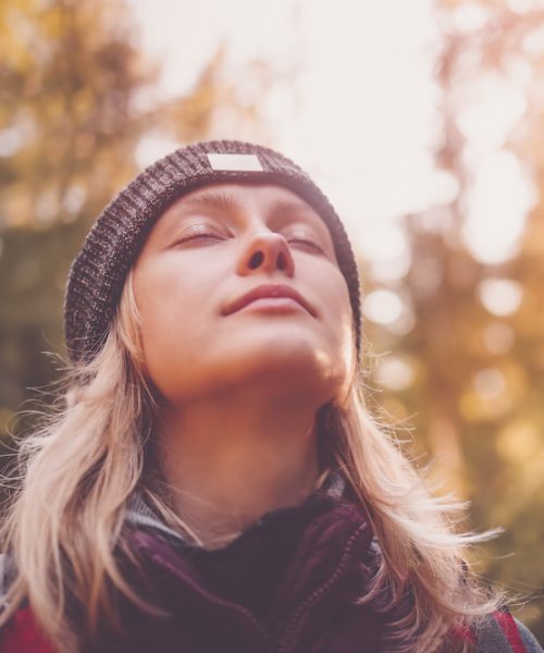 Young woman hiking and going camping in nature. Person with backpack walking in the forest