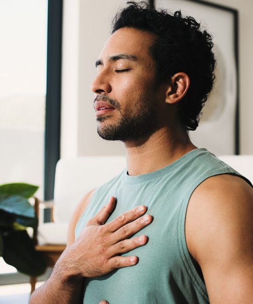 Meditation, calm man or home for breathing routine, relaxation or body awareness practice for wellness. Mindfulness, inner peace or person with holistic breathwork exercise, yoga or mental health zen.