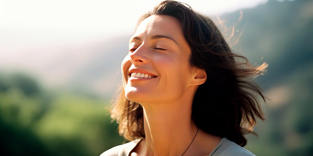 Middle-age woman breathing fresh air in the mountains.