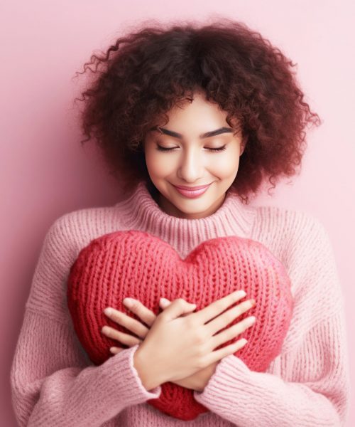 Young woman hugging a heart shaped for self love concept