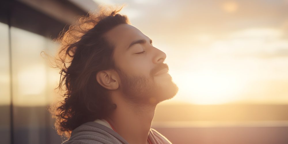 A focused view of a calm man, deep in morning meditation, refreshingly breathing in the morning air.